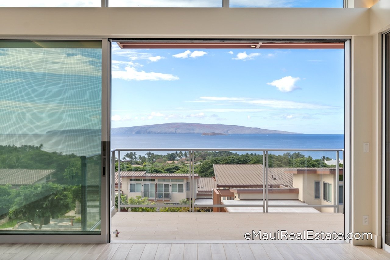 Large sliding glass doors retract to connect the living room with the lanai